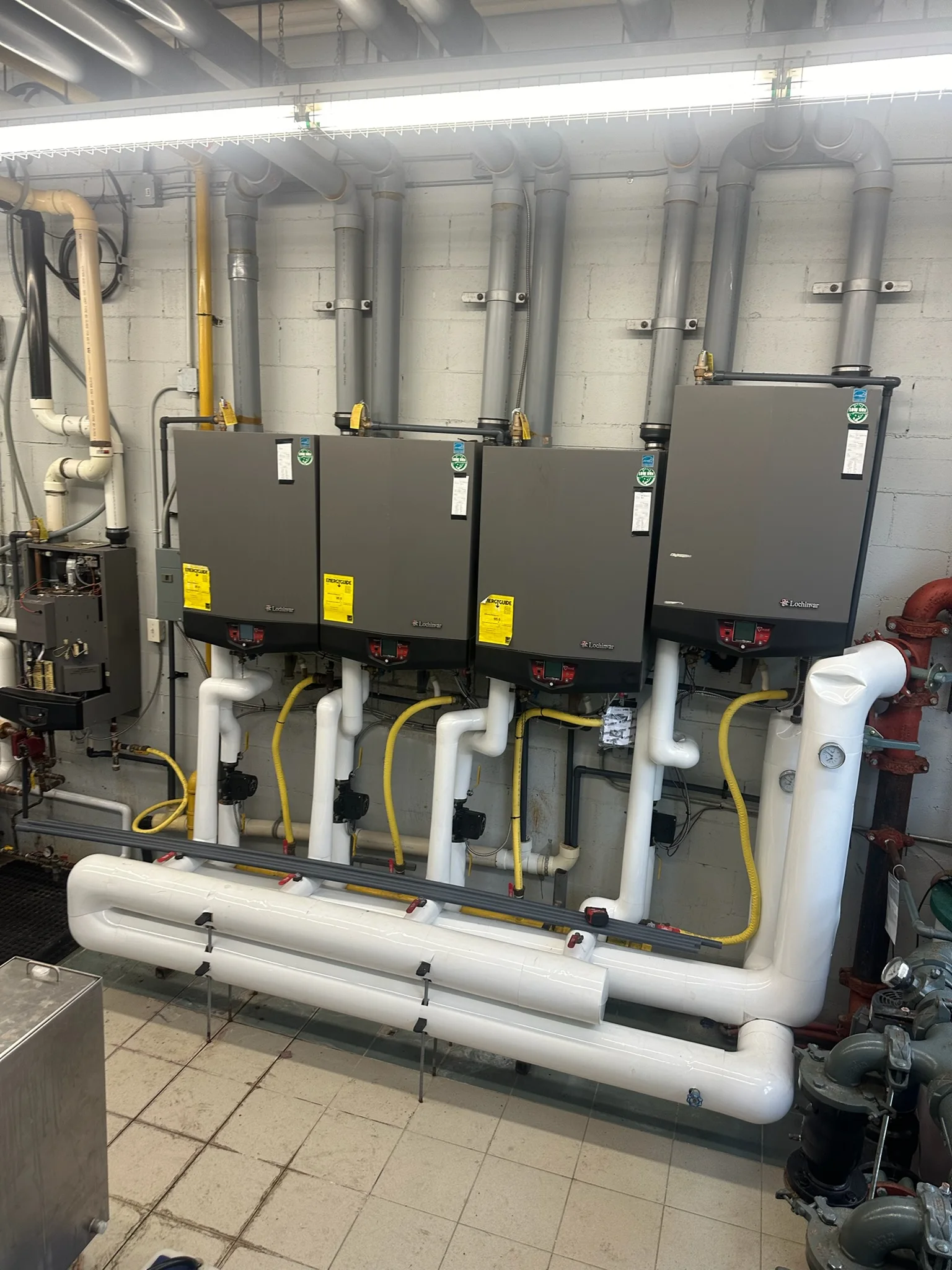 Four wall-hung Lochinvar boilers with insulated header piping