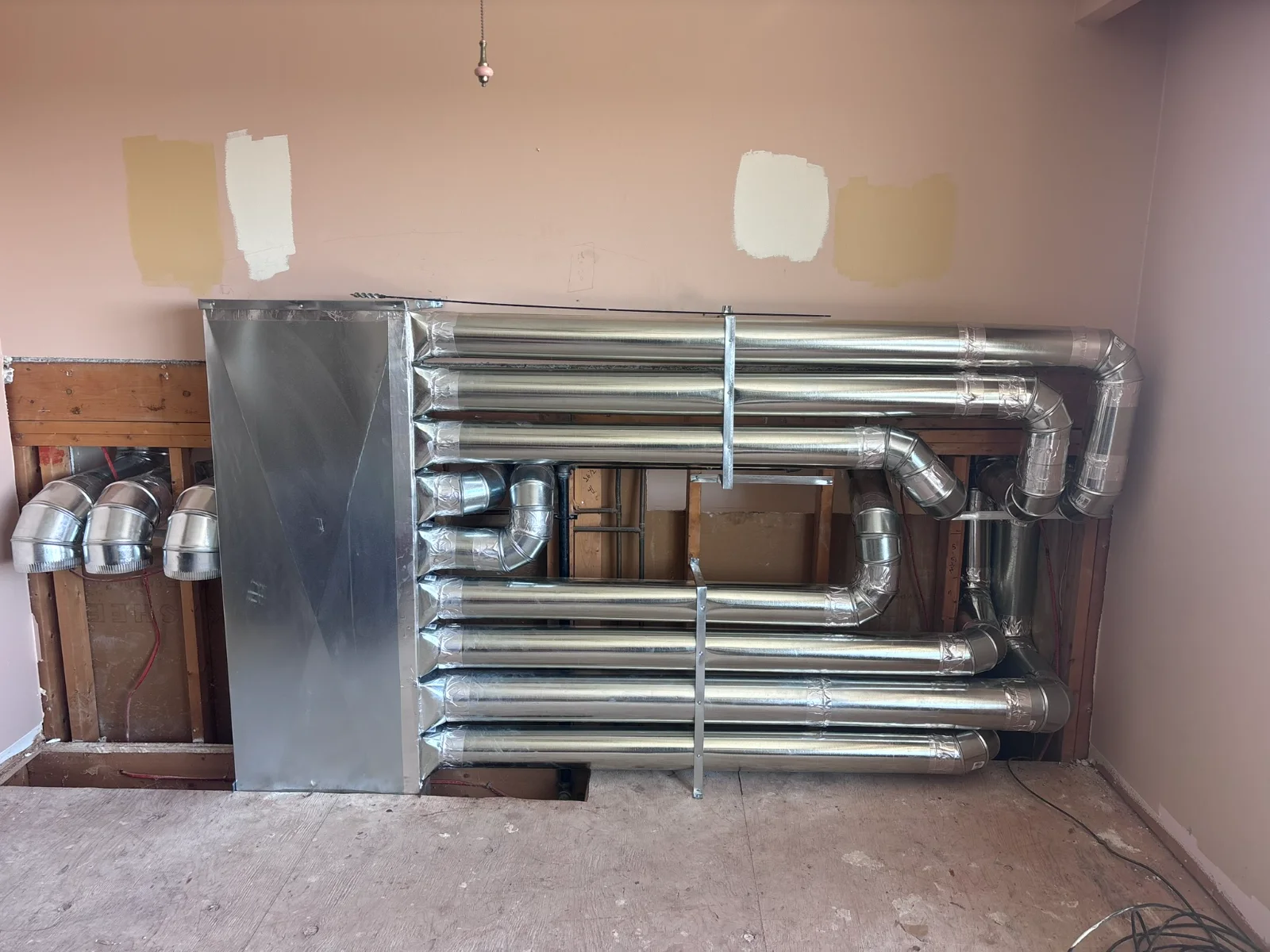New galvanized supply duct runs installed along an open wall