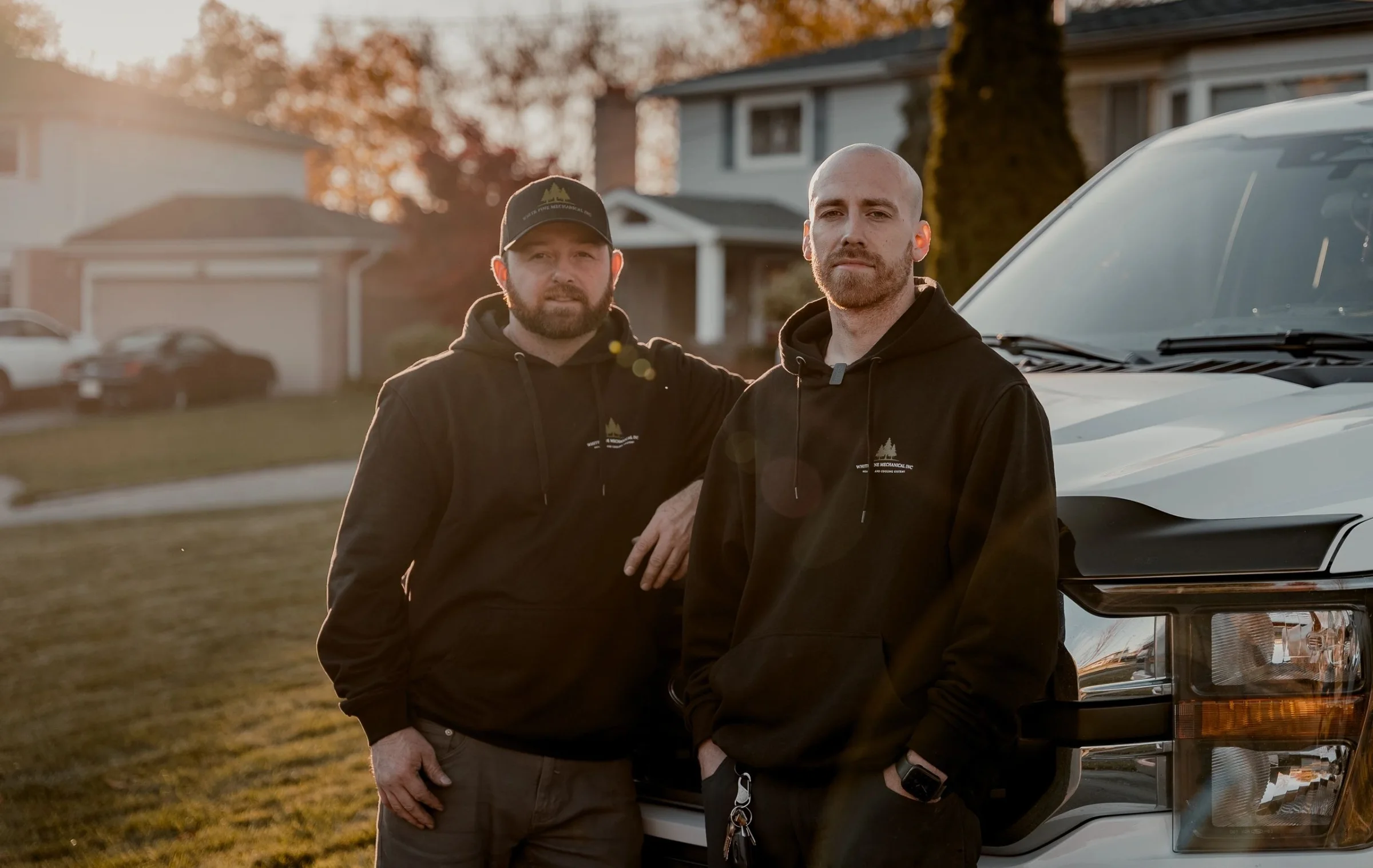 Owners Kevin Borden and Austin Large beside their White Pine Mechanical service trucks
